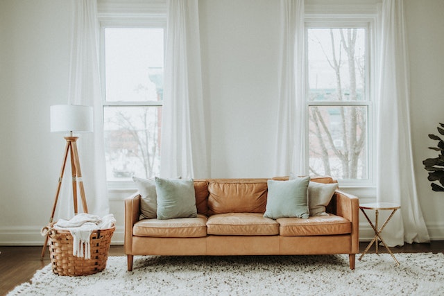 a beige sofa in front of a large window
